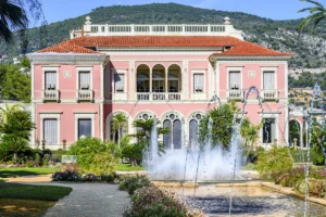 Pink mansion with fountain and lush gardens